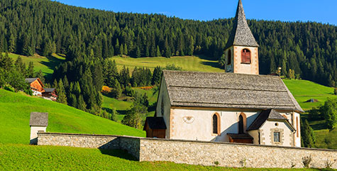 Pragser Kirche mit Wald im Hintergrund