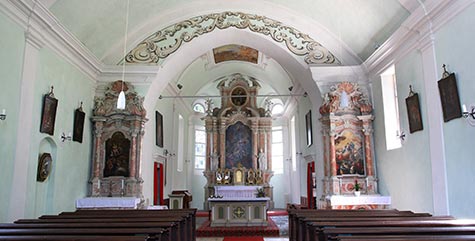 Innenansicht der St. Katharina in Bruneck mit kunstvoll gestalteten Altären