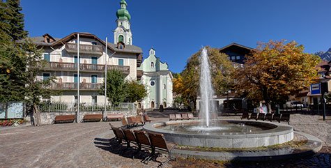 Piazza con fontana e panchine a Dobbiaco