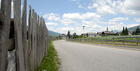 Landstraße nach Pfalzen mit Holzzaun als Begrenzung